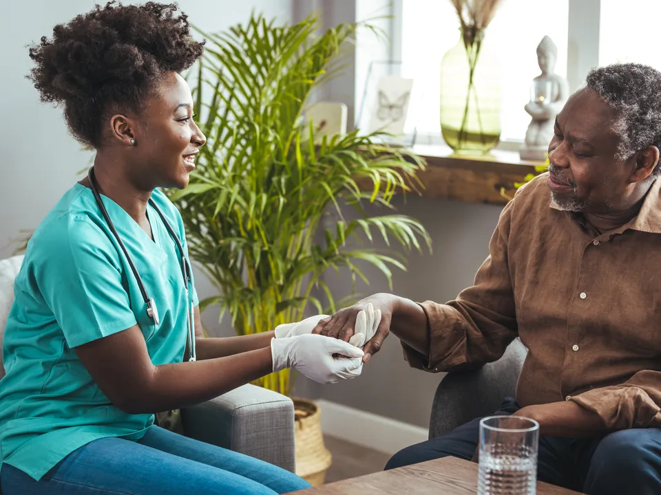 A care manager visiting an older man at his home